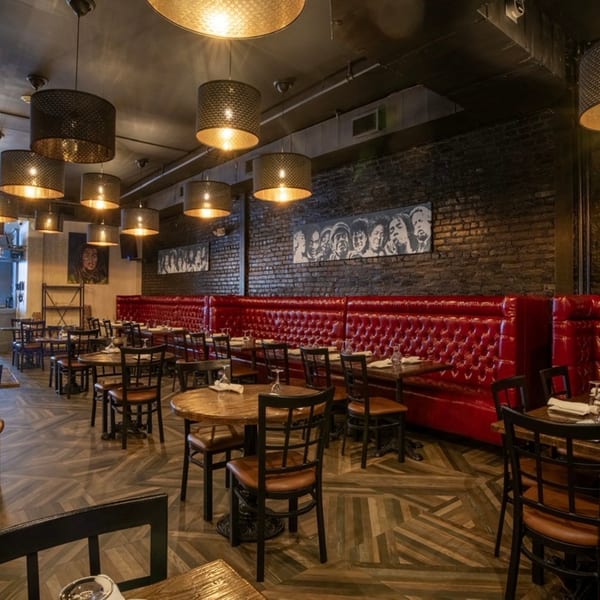 Krave restaurant interior with red booth seating, wooden tables, black chairs, and pendant lights.